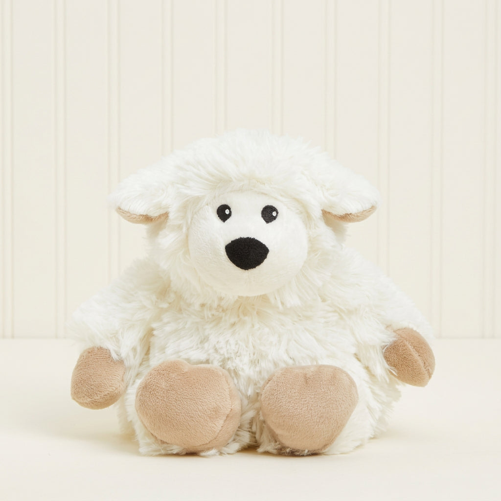 A small white plush sheep toy with beige paws and ears, black embroidered eyes, and a black nose, sitting against a plain cream background.