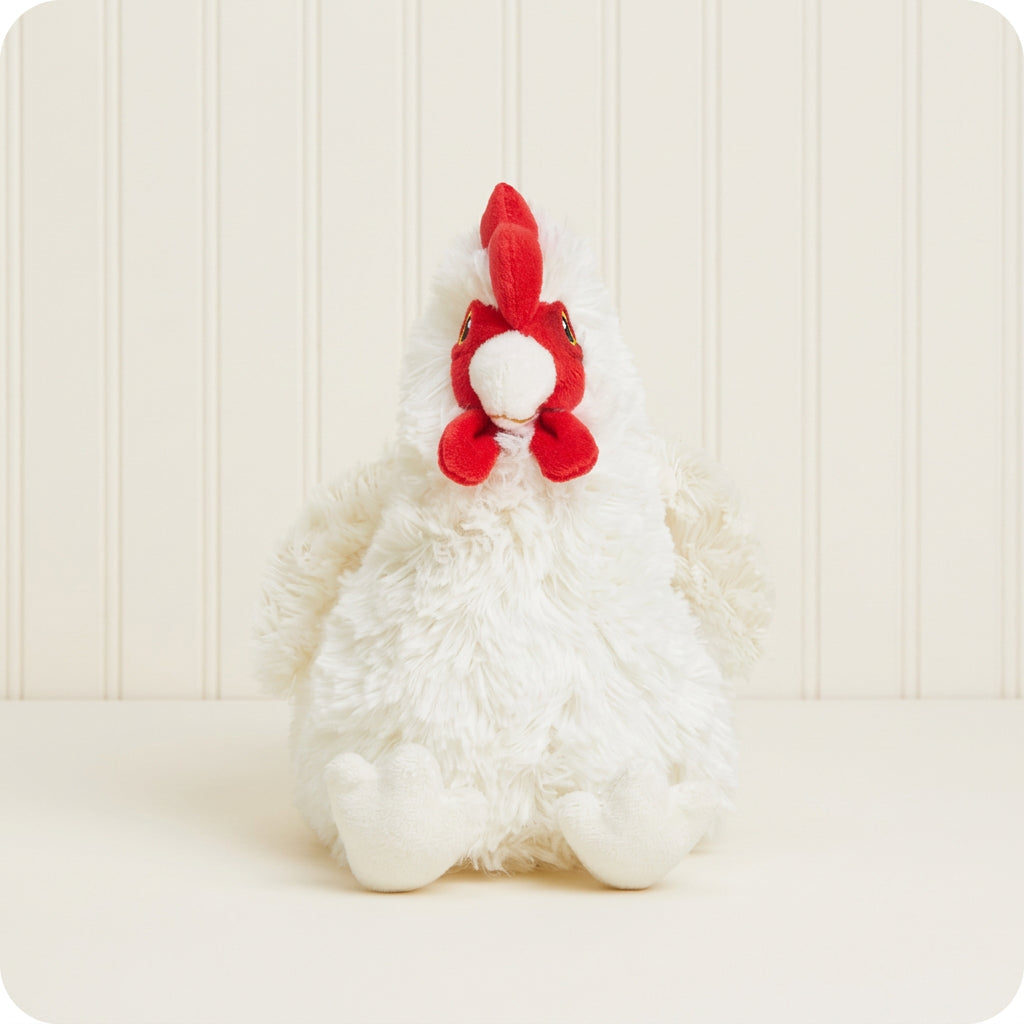 A white plush chicken toy with a bright red comb and wattle, sitting against a plain off-white background.